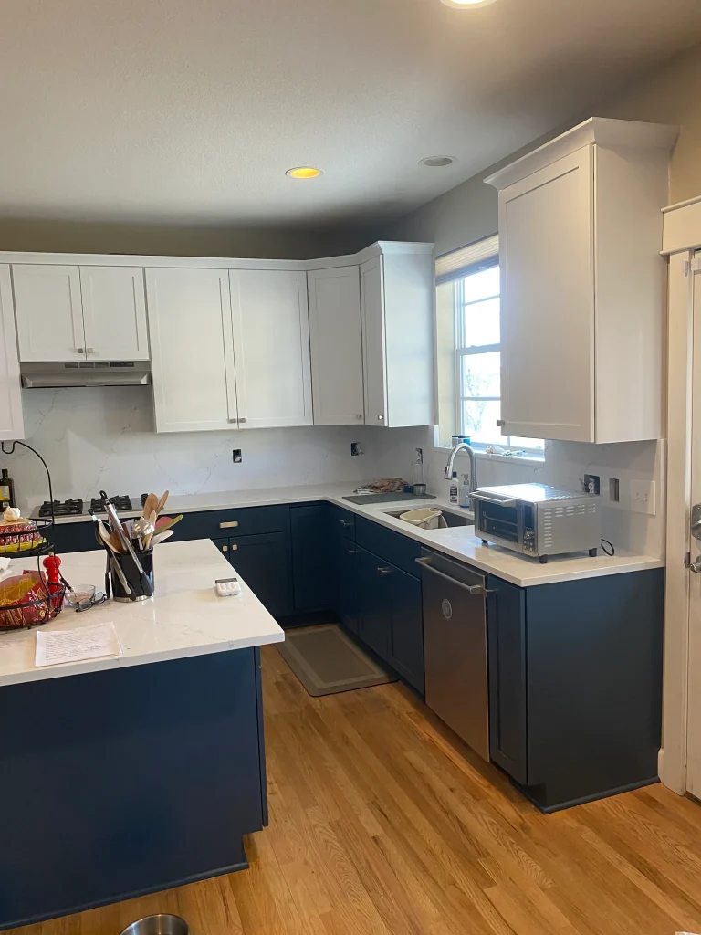 Completed Denver cabinet refacing project with bright white cabinets and deep blue island