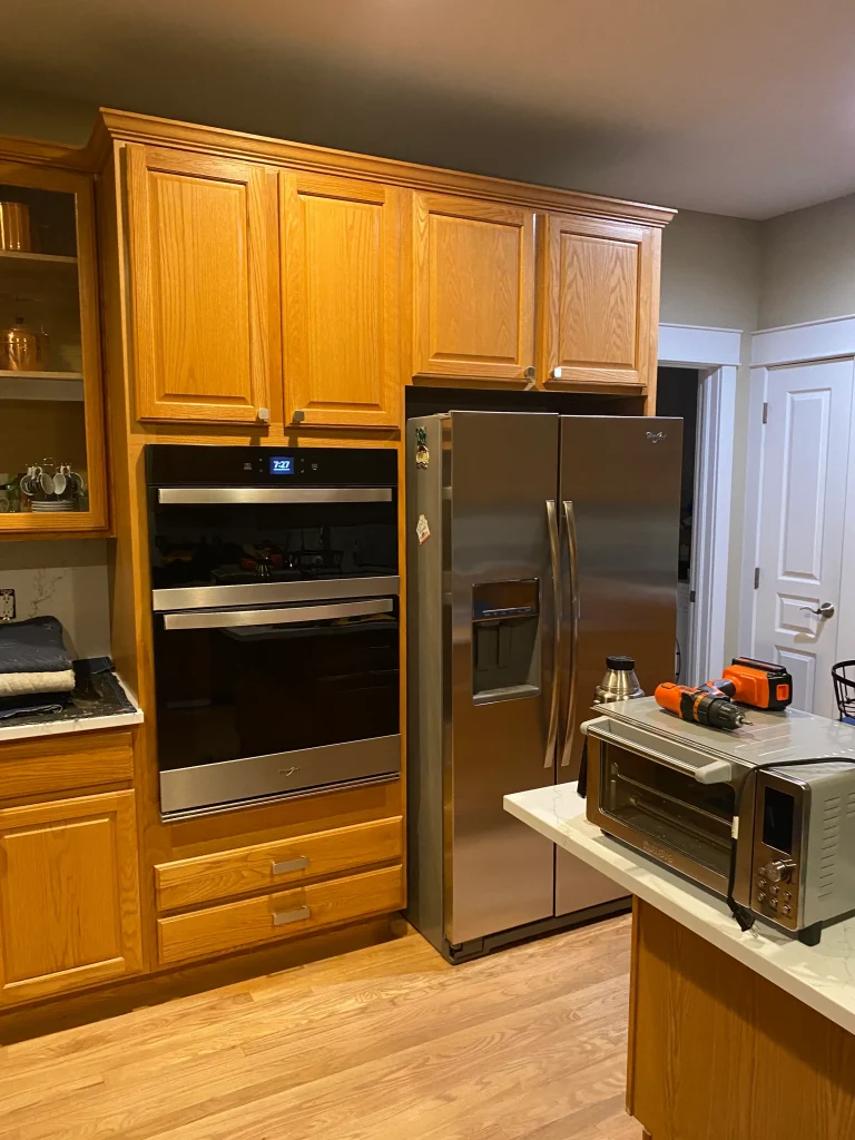 Outdated Denver kitchen before cabinet refacing featuring oak cabinetry and stainless steel appliances